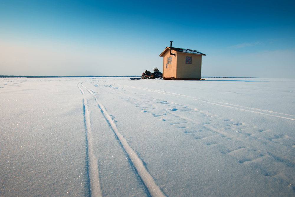 Ice fishing hut on frozen lake