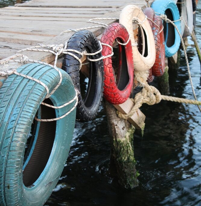 Colourful tires hanging on the right side of a dock
