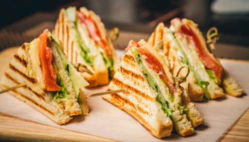 Four chicken club sandwiches on cutting board