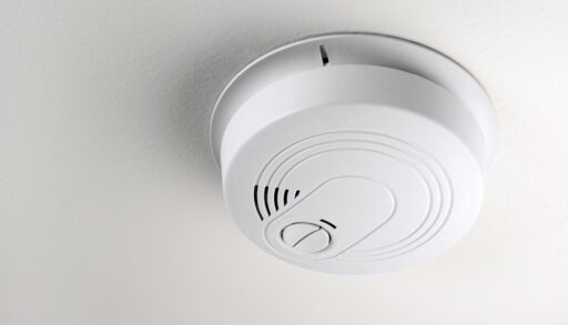 Close-up of a smoke detector on a ceiling.