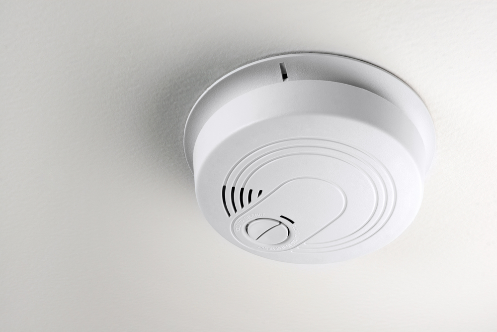 Close-up of a smoke detector on a ceiling.
