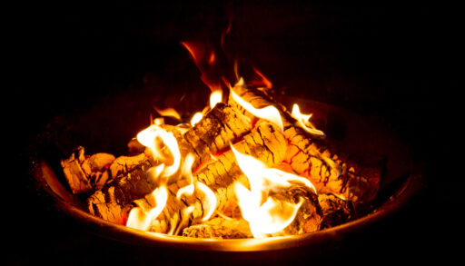 Close-up of a fire pit burning at night.
