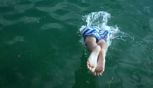 Back of young boy diving into water