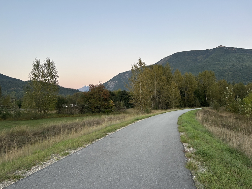 A paved road running through a mountainous landscape at dusk.