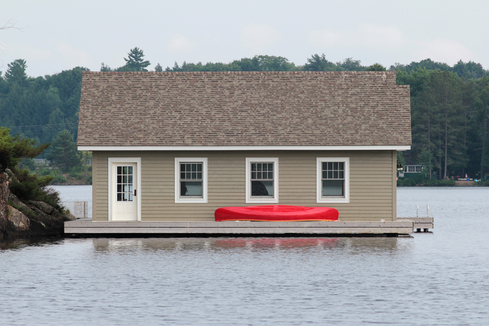 Side view of a boathouse with a red canoe.