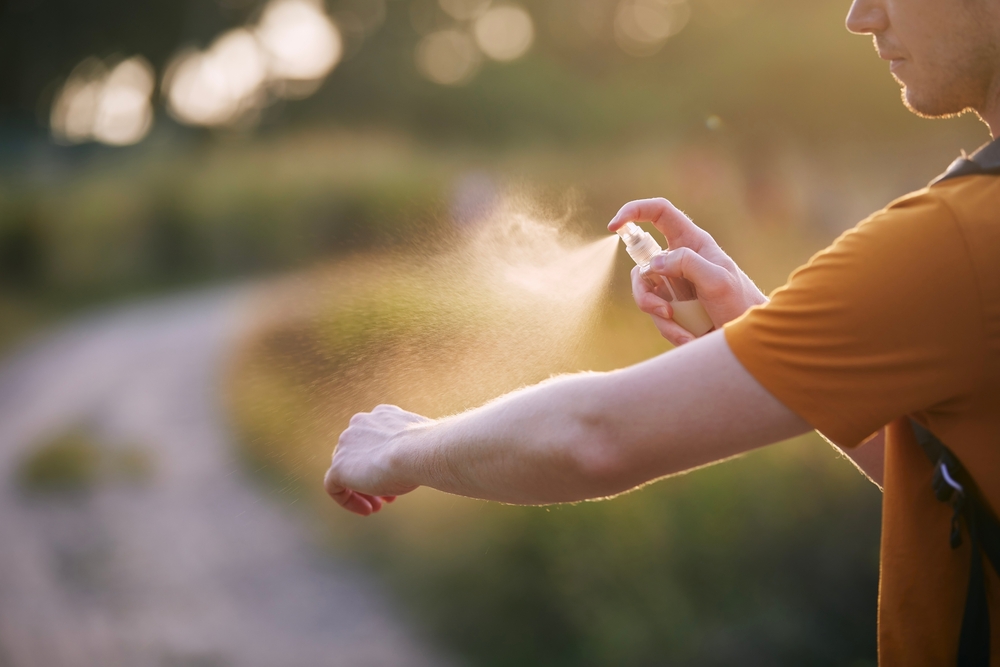 Man applying insect repellent to his arm.