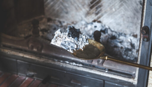 Small shovel scooping ashes out of a fireplace.