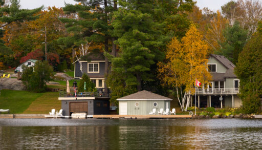 Cottages next to a shoreline with a Canadian flag.