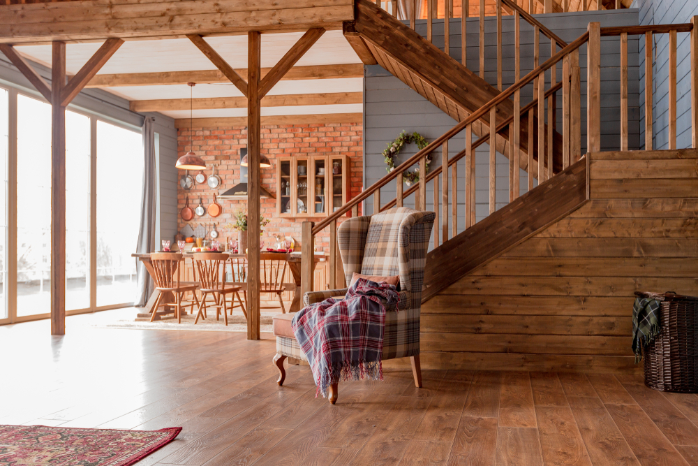 Interior of a cabin living room with a staircase and armchair.