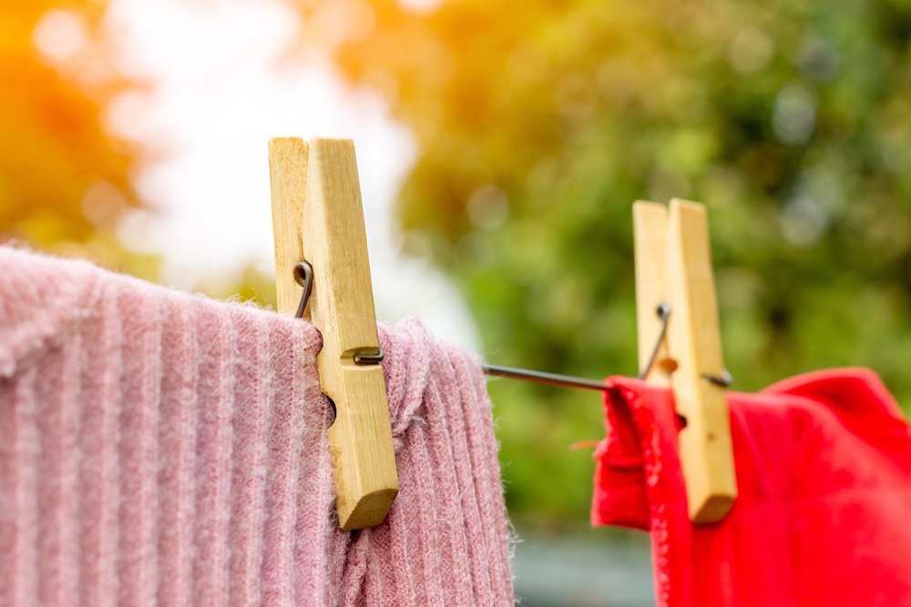 Close-up of clothes-pins holding clothing on a clothesline.