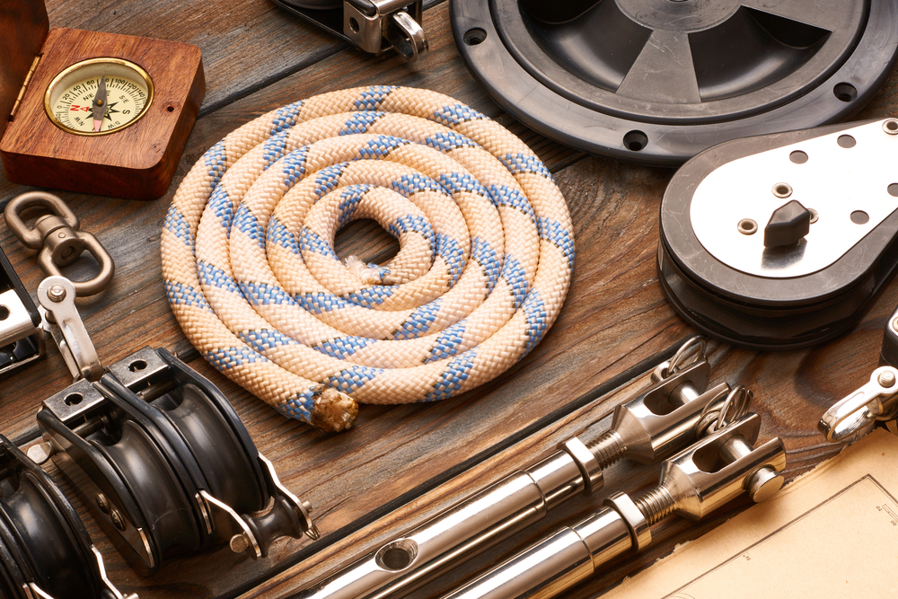 Flat-lay of various boating supplies including rope and a compass.
