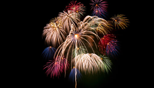 Different coloured fireworks light up a night sky.