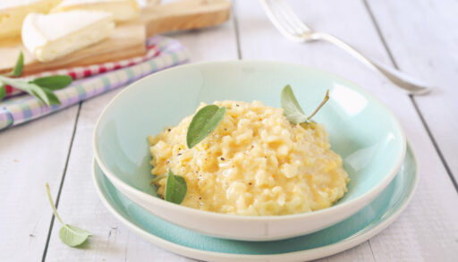 Bowl of plain risotto garnished with sage leaves.