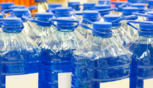 Jugs of blue antifreeze lined up in rows.