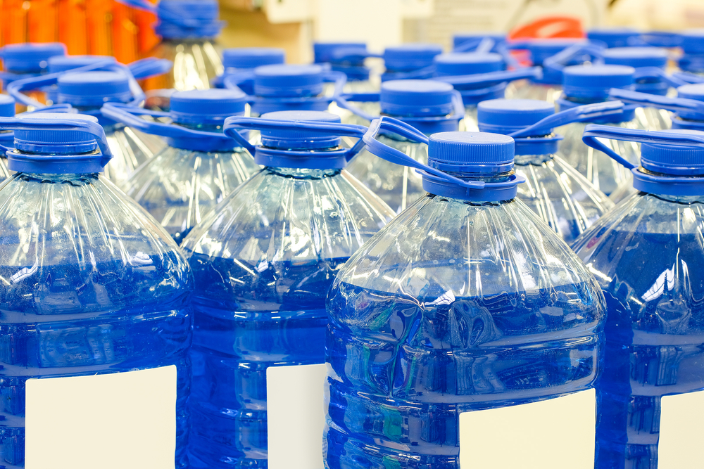 Jugs of blue antifreeze lined up in rows.