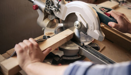 Carpenter using a mitre saw to cut a piece of wood.