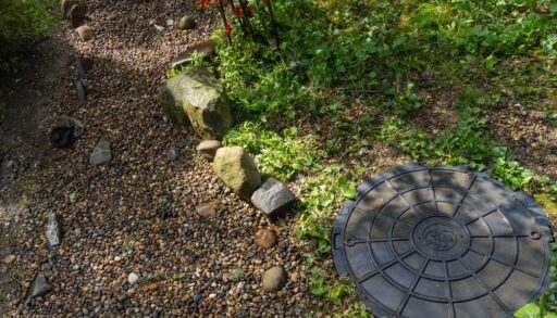Overhead view of the drainage cover of a septic tank in a forest.