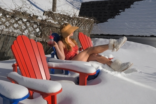 Woman in a bathing suit suntanning in the winter.