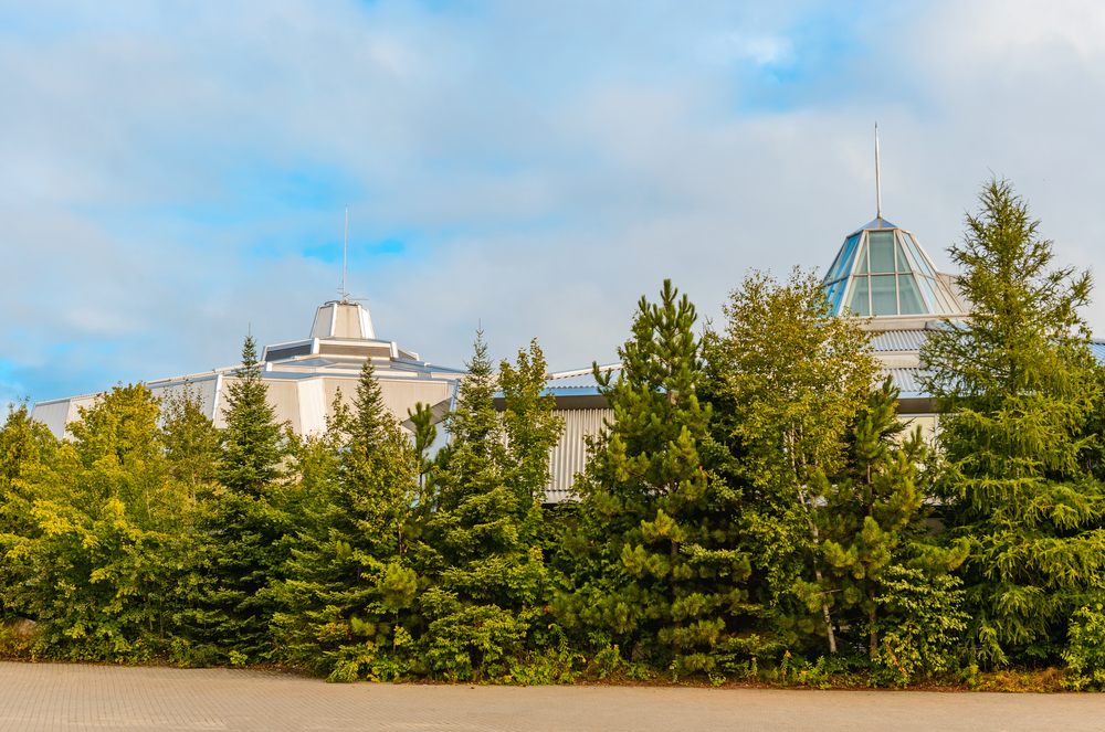 View of Science North, Sudbury behind pine trees.