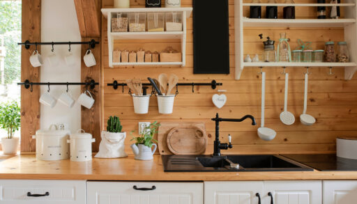 Rustic cottage kitchen with white cabinets and wood countertops and walls.