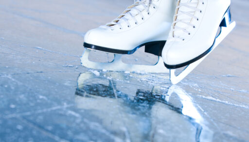 Close-up on figure skates in blue ice.