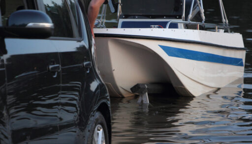 Blue and white boat being put in the water.