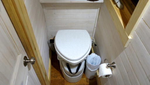 Composting toilet in a room with wood panelling.