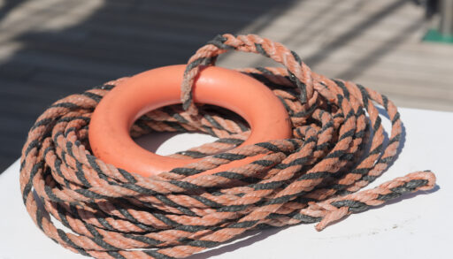 Orange life buoy and orange and black rope.