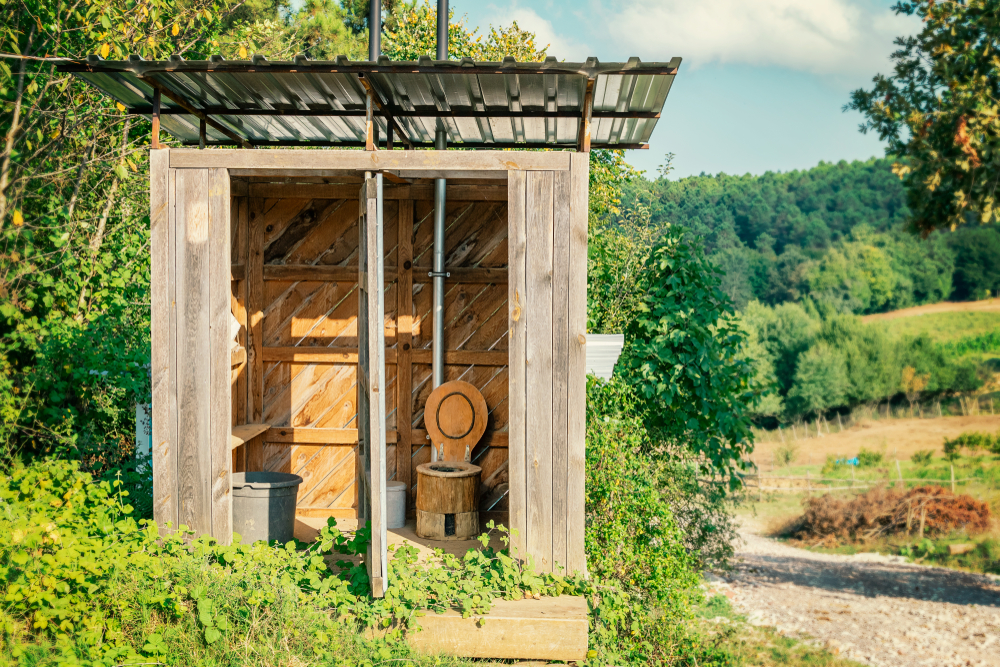 Wooden outhouse with no doors in a forest.