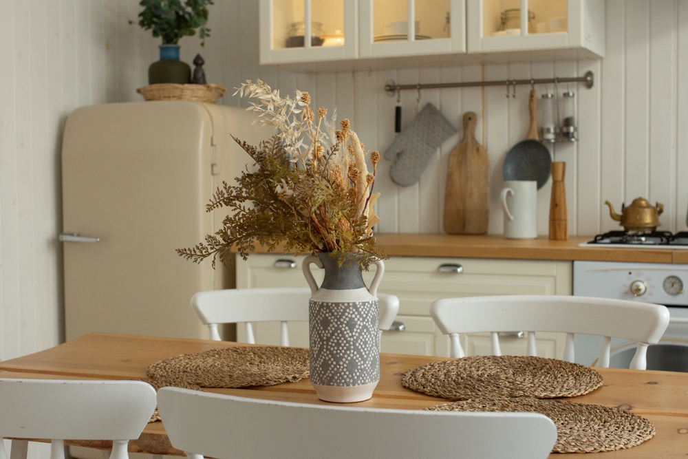 White kitchen with a tan-coloured fridge and a wooden dining table.