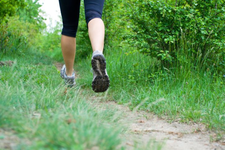 Woman cross country running on trail