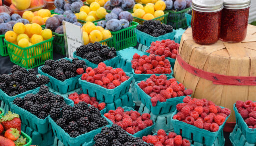 Raspberries and blackberries stacked in blue cartons.