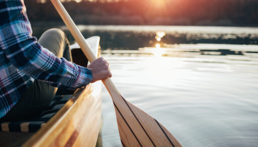 Close-up of a person holding an oar while canoeing.