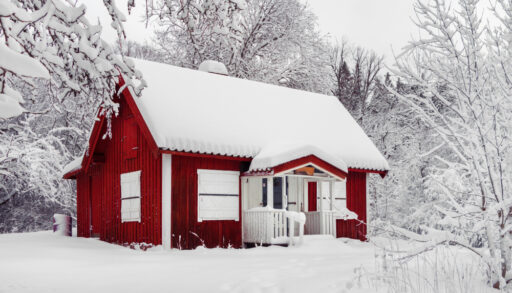Small red cottage covered in snow.