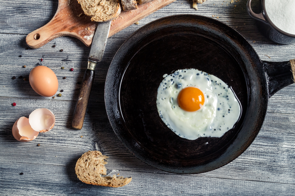 Overhead view of a fried egg in a black cast iron pan.
