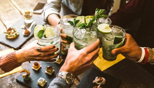 Group of people raising glasses at a dinner table.