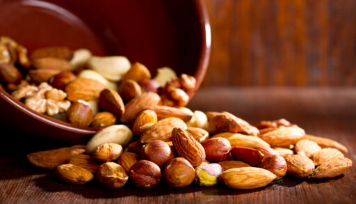 Mixed nuts poured onto a wooden table.