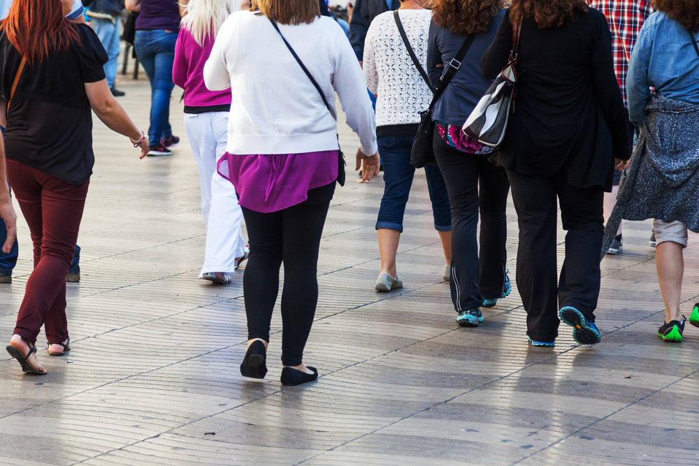 Crowd of people walking in a city.