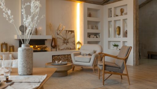 White and beige-coloured living room with a warm, yellow light and fireplace.