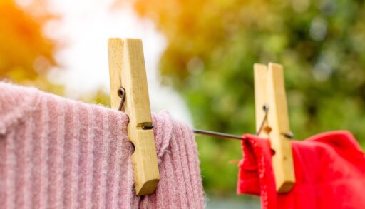 Close-up of clothes-pins holding clothing on an outdoor clothesline.