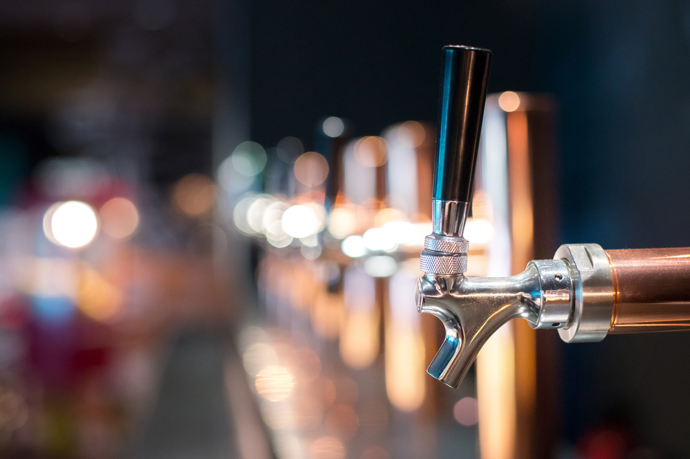 Close-up of a beer tap in a row at a bar.