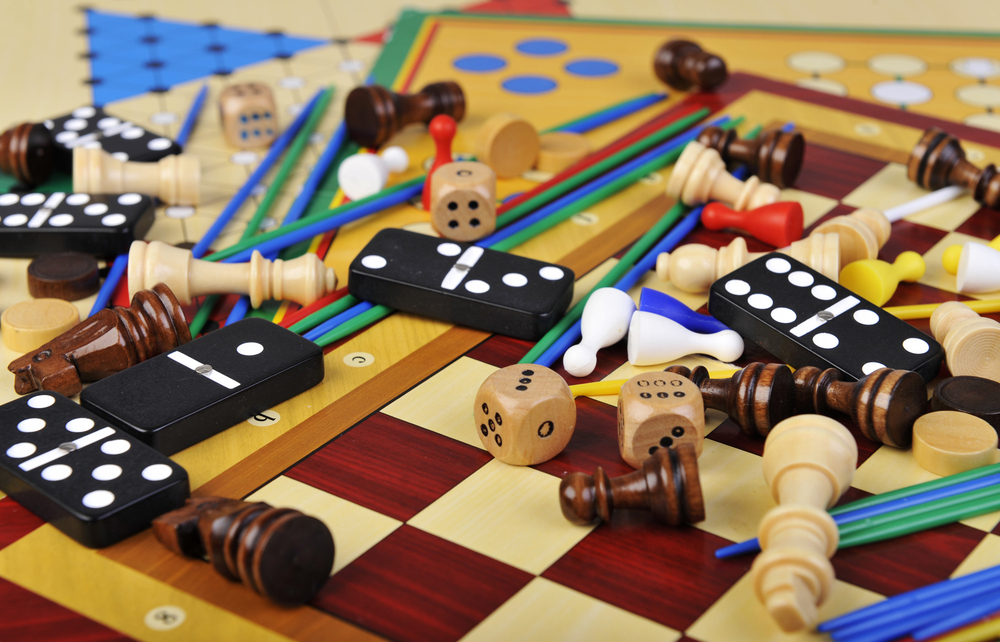 Close-up of various board game pieces such as dominos, dice and chess pawns.