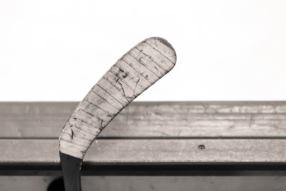 Hockey stick blade leaning against the top of hockey boards.