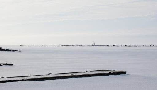 Snow-covered docks along a frozen Lake Huron.