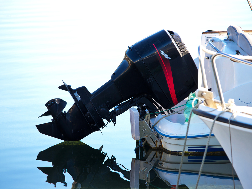 Black boat engine attached to the back of a boat.