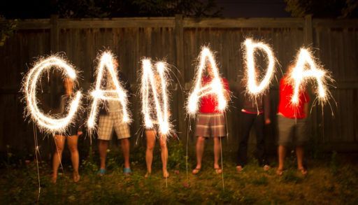 People hold up sparklers spelling "Canada".