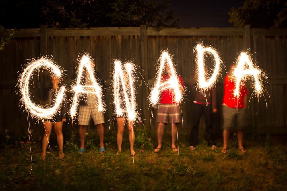 People hold up sparklers spelling "Canada".