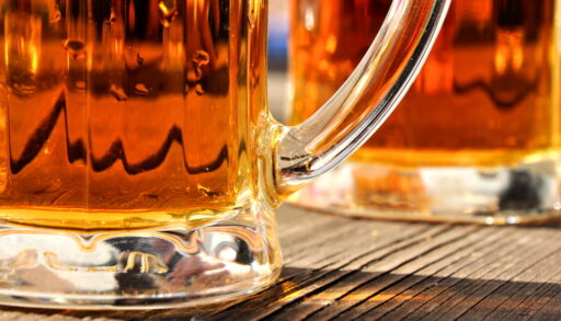 Close-up of the bases of two beer glasses on a table.