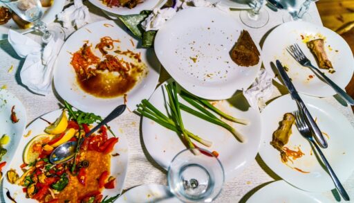 Pile of dirty dishes on a table.