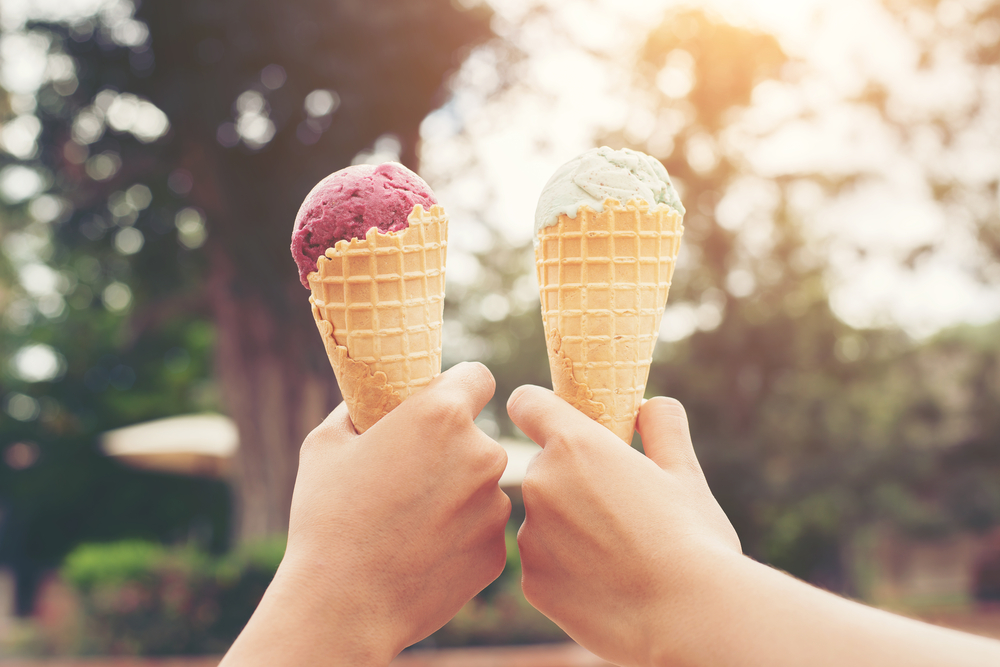 Two people holding ice cream cones.